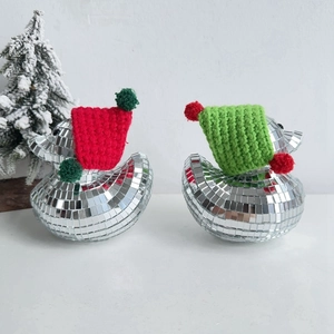Close-up of disco ball glass ducks with red and green knitted hats for Christmas decor