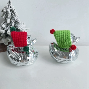 Close-up of disco mirror ducks wearing red and green knit hats for Christmas decor