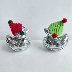 Close-up of disco ball mirror foam ducks with festive red and green knitted hats