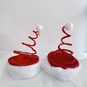 Detail of red and white spiral spring Christmas hats with plush trim and golden bells