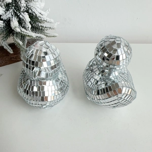 Detailed view of two handmade disco ball mirror ducks reflecting light on white background