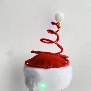 Detail of red spiral Christmas hat with LED lights, velvet fabric and a gold jingle bell