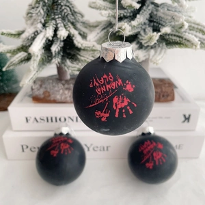 Three matte black Halloween ornaments with red bloody handprints and Wanna Play text