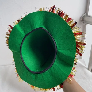 Detail view of a green felt holiday hat with shiny red and gold fringe trim for festivals