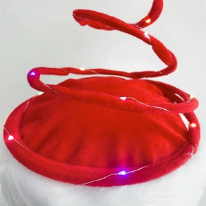 Detail of red velvet spiral spring Christmas hat with colorful integrated LED fairy lights