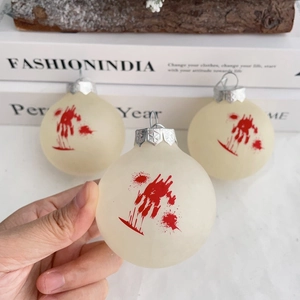 Macro shot of Halloween ornaments featuring red blood handprints on matte white balls