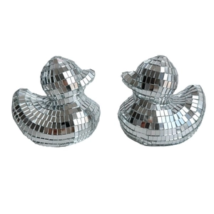 Detailed macro view of two silver disco mirror glass ducks for creative home party decor