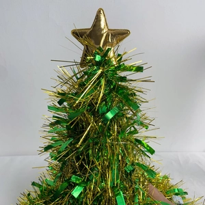 Macro detail of a green and gold fringe Christmas tree decor with star topper