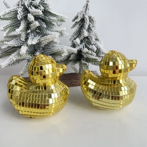 Close-up of golden disco mirror duck figurines with reflective glass tiles for home decor