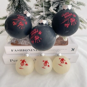Detail of Halloween decorative balls with bloody handprints on a winter themed tree