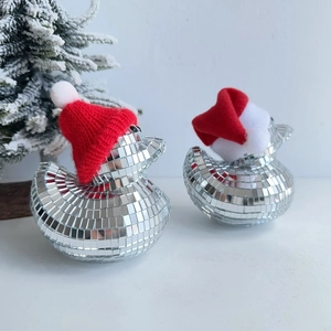 Close-up of sparkling silver disco ball ducks wearing red knit Christmas hats for decor
