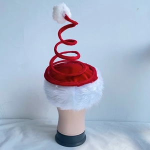 Detail of creative red and white spiral spring Christmas hat with plush pom-pom and soft fur