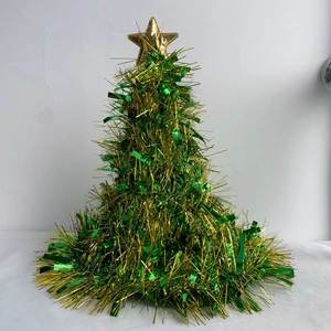 Detail of green and gold Christmas tree decoration with shiny gold star topper on top