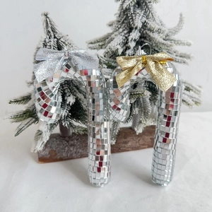 Disco ball mirror candy cane Christmas ornaments with glitter bows on snowy tree branches