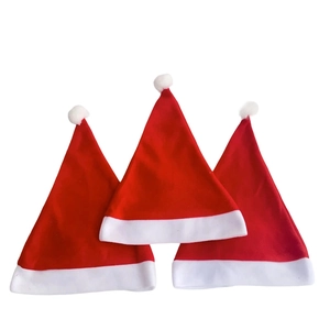 Classic red plush Christmas hats set with white pompoms for holiday festive costumes