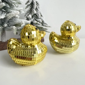 Close-up of golden disco mirror glass duck ornaments with reflective square mosaic tiles