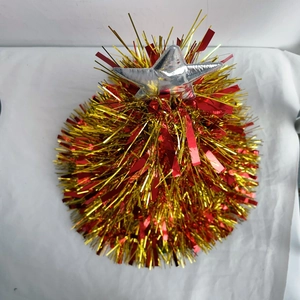Detail of red and gold Christmas tinsel tree topper with a shiny silver star ornament