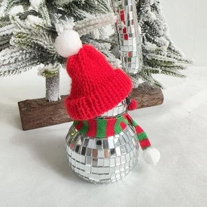 Close-up of reflective disco mirror snowman ornament with red hat and striped scarf