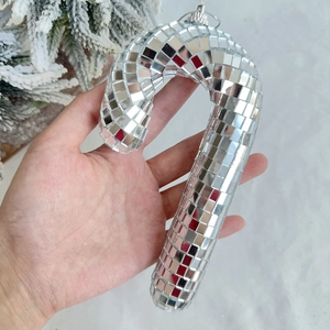 Close-up of silver disco ball candy cane ornament with reflective mirror glass surface