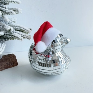 Close-up of disco mirror Christmas duck with red plush hat on snowy white background