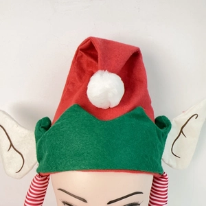 Détail du chapeau d'elfe rouge et vert avec pompon blanc et oreilles d'elfe pointues