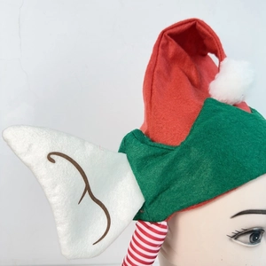 Vue latérale du bonnet de lutin de Noël en feutre rouge et vert avec des oreilles blanches