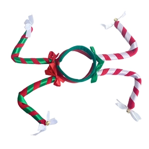 Detailed view of red and green striped Christmas headbands with golden bells and bows