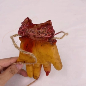 Realistic bloody severed hand prop for Halloween with red flesh texture and hemp rope