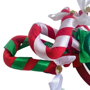 Close-up of Christmas headband with red-white stripes, green bow and golden bell