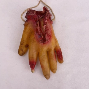 Detail of bloody severed hand prop with realistic skin texture and hanging hemp rope