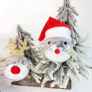 Detail view of transparent Christmas balls with Santa and reindeer motifs on a tree
