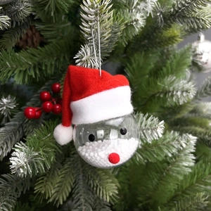 Close-up of Santa Claus hanging ornament with white snow filling on Christmas tree branches