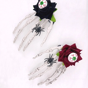Détail de pince à cheveux Halloween avec main squelette, rose rouge et œil effrayant