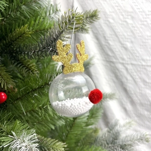 Gros plan d'une décoration de Noël renne avec bois pailletés sur un sapin