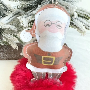 Detailed close-up of a Santa Claus faux leather keychain with decorative white stitching