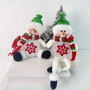 Close-up of LED glowing snowman dolls with green knit hats and red snowflake patterns