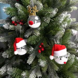 Detail of Christmas tree ornaments featuring clear reindeer and Santa Claus themed baubles