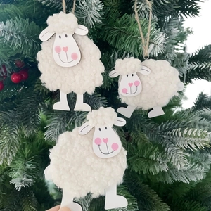 Three cute felt sheep ornaments with wood limbs hanging on a festive Christmas tree