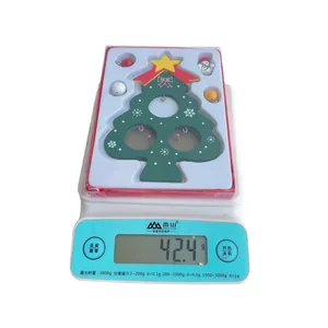 Green DIY wooden Christmas tree ornament showing exact weight on a digital scale