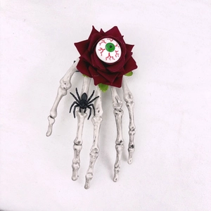 Détail de pince à cheveux Halloween avec main de squelette, rose rouge et oeil gothique