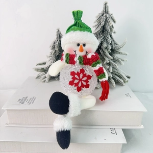 Detail of a plush Christmas snowman LED ornament with a green hat and red knit scarf