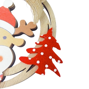 Detail of wooden Christmas ornament with painted Santa Claus and red felt tree accent