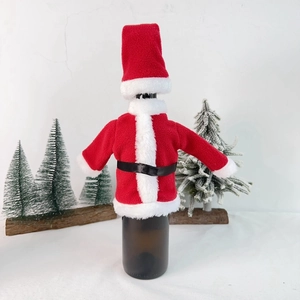 Detail of red plush Santa suit wine bottle cover with faux fur trim and black belt decoration
