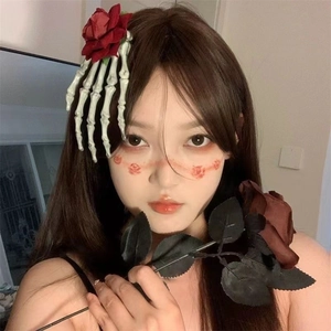 Détail de la pince à cheveux Halloween avec main de squelette blanc et rose rouge