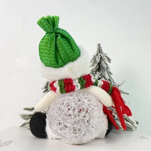 Detailed view of an acrylic snowman ornament with green plaid hat and red knitted scarf