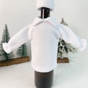 Detail of white fleece Christmas wine bottle sweater with a mini hat for festive table decor