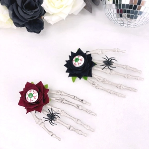 Détail de barrettes main de squelette avec roses rouges, globes oculaires et araignées
