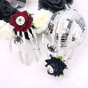 Détail des pinces à cheveux main de squelette d'Halloween avec yeux sanglants et roses