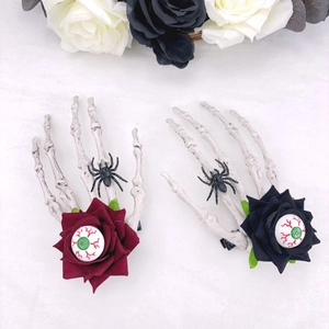 Détail de pinces à cheveux main squelette avec roses rouges, araignées et yeux effrayants