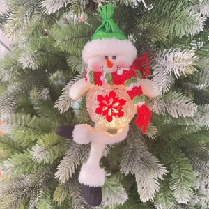 Close-up of a plush snowman Christmas ornament with LED warm light and snowflake pattern